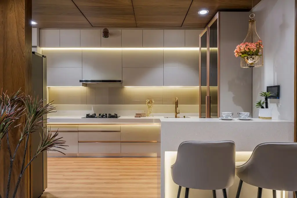 L-shaped modular kitchen with breakfast counter and under-cabinet lighting